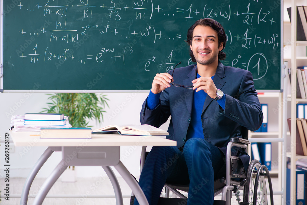 Young handsome man in wheelchair in front of chalkboard Young handsome man in wheelchair in front of chalkboard