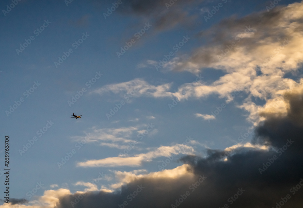 Passenger jet airplane on the background of the cloudy sky. Spring evening, overcast. Airplanes take off from the airport nearby.