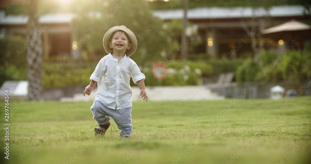 Cute emotinal baby running on grass in garden. Little adorable kit happily smiling and laughing - happy childhood concept 4k Cute emotinal baby running on grass in garden. Little adorable kit happily smiling and laughing - happy childhood concept 4k