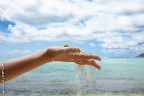 Sand Falling Through Her Hands On The Beach