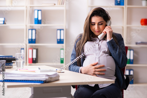 Young pregnant woman working in the office  photo