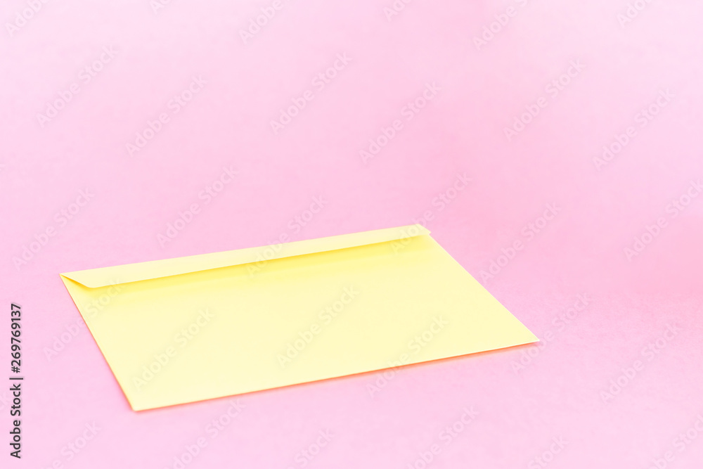 Beauty yellow envelope; branding mock up; front view on pastel pink background.