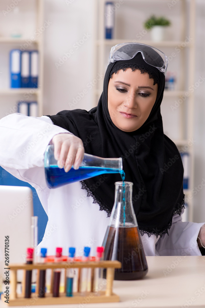 Female chemist in hijab working in the lab Female chemist in hijab working in the lab