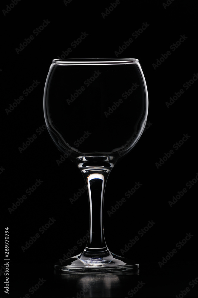 Wineglass consecrated by silhouette light with reflection on a black background Wineglass consecrated by silhouette light with reflection on a black background