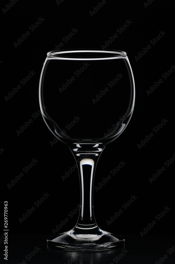 Wineglass consecrated by silhouette light with reflection on a black background Wineglass consecrated by silhouette light with reflection on a black background