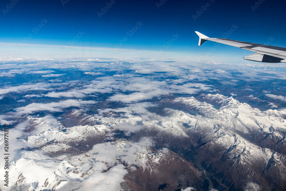 wing of an airplane flying above the clouds wing of an airplane flying above the clouds