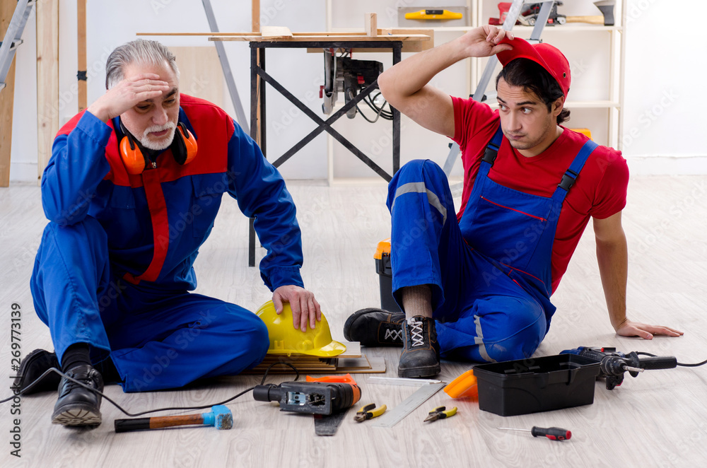 Fototapeta premium Two professional contractors laying flooring at home 