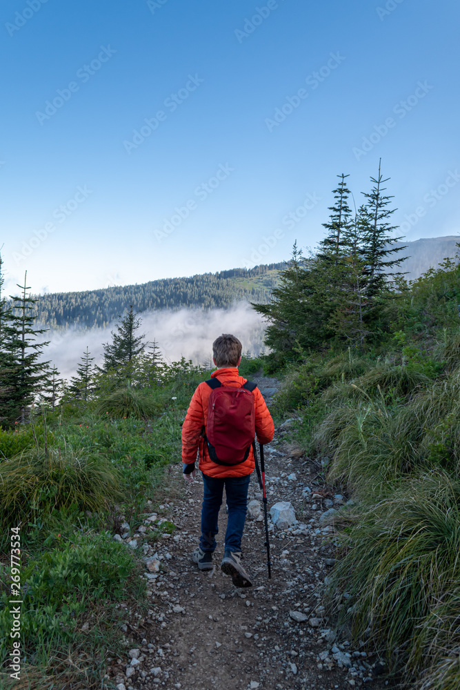 Boy hiking down trail in the northwest