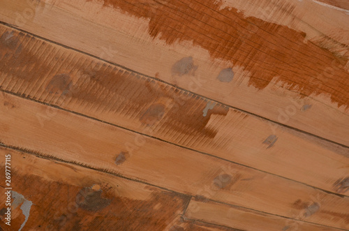 A close-up photograph of some pale wooden beams, detailing the stains and markings of construction. They have been used for the hull of a boat.