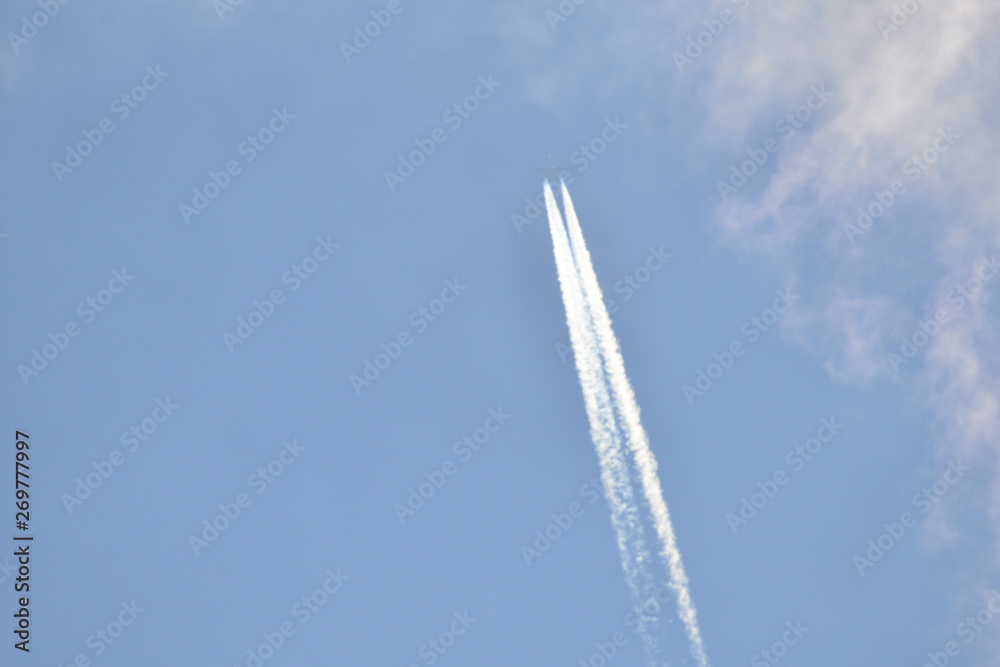 airplane with contrail in sunny sky at very high altitude airplane with contrail in sunny sky at very high altitude