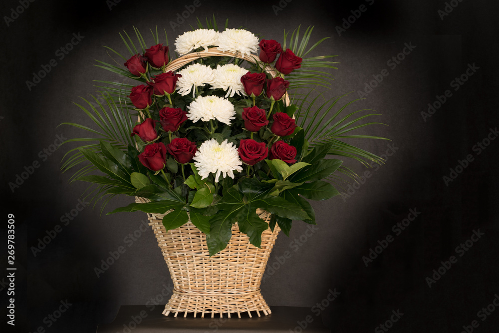 Ritual funeral basket with flowers on a black background The flower