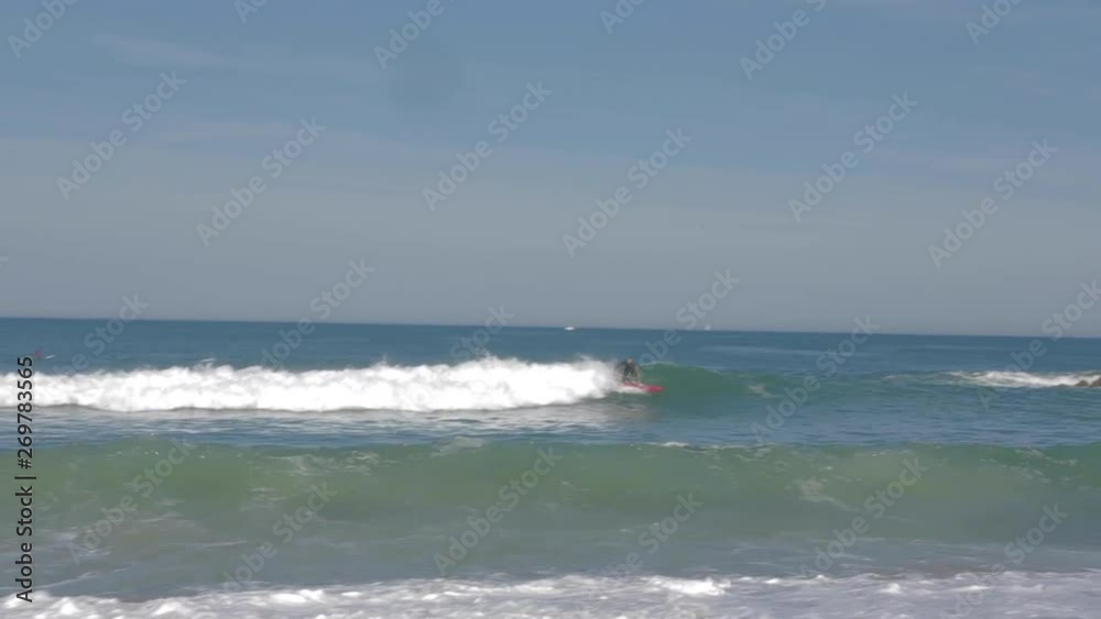 Two Surfers surfing a little wave in sunny atlantic ocean at beach in Biarritz, France. A Surfer falling down. 4K. Wide shot. Two Surfers surfing a little wave in sunny atlantic ocean at beach in Biarritz, France. A Surfer falling down. 4K. Wide shot.