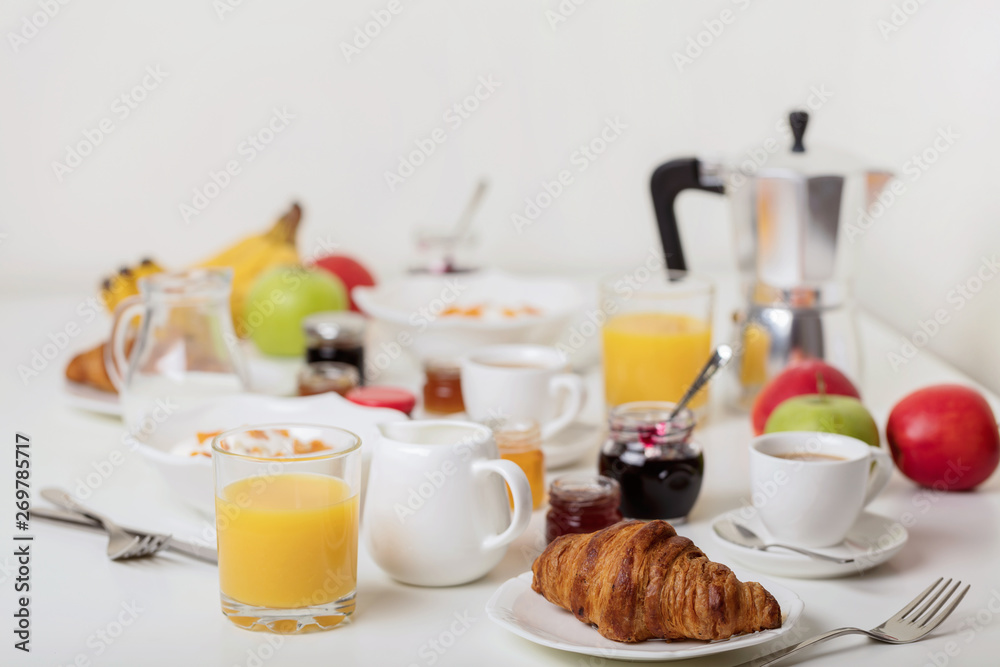 Breakfast time. Croissants and orange juice, jam and honey. Coffee with cream or milk. Fruits - bananas, red and green apples. Ricotta with sour cream, nuts and dried apricots. Breakfast time. Croissants and orange juice, jam and honey. Coffee with cream or milk. Fruits - bananas, red and green apples. Ricotta with sour cream, nuts and dried apricots.
