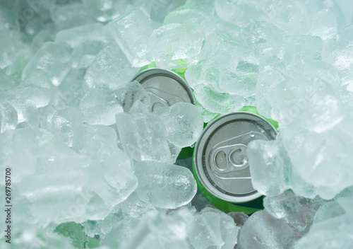 Obraz na plátně close up on drinking cans inside ice blocks in the cooler
