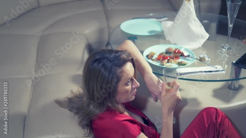 woman gets drunk at home alone at a table set for two for a romantic date, as her partner did not come on a date