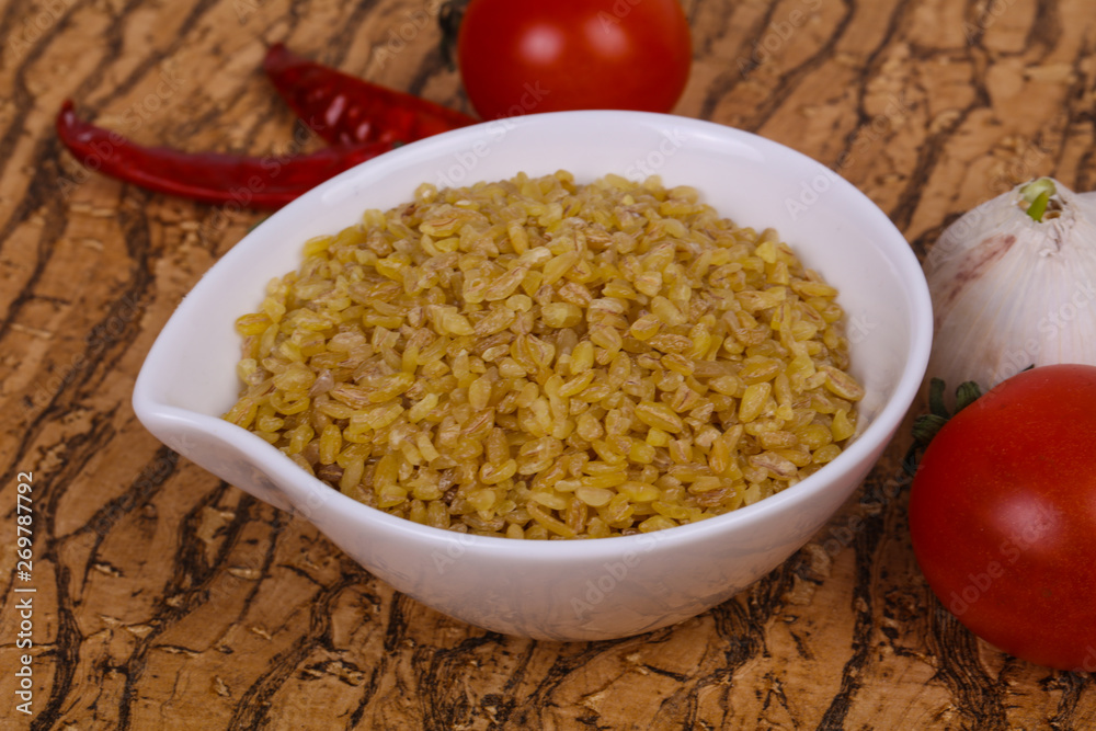 Raw bulgur in the bowl with tomatoes and garlic Raw bulgur in the bowl with tomatoes and garlic