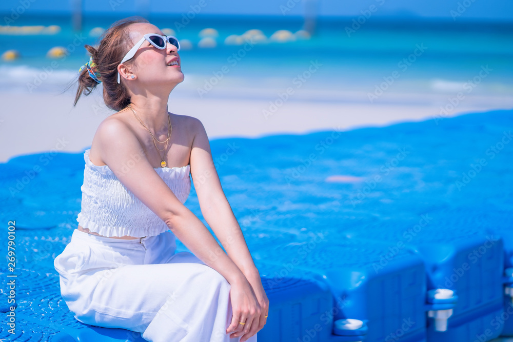 Travel and Vacation. Freedom and relax Concept. excited woman in white dress and sunglasses on The Beach enjoying summer under the blue sky