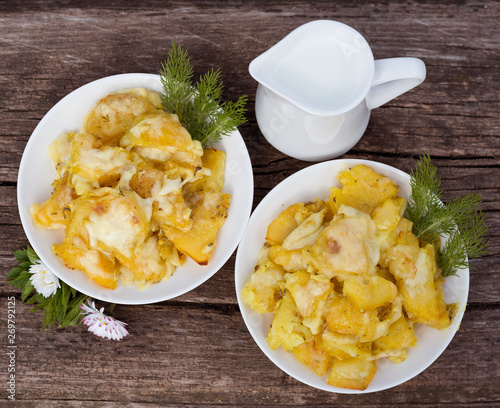 Plate of fried potatoes with sour cream and cheese with milk - country lunch