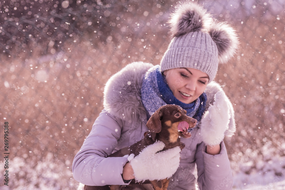 Obraz premium Woman playing with dog during winter