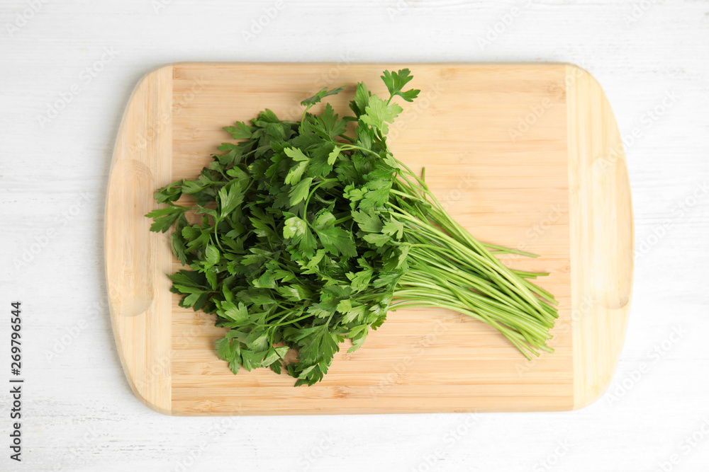Board with fresh green parsley on wooden background, top view Board with fresh green parsley on wooden background, top view