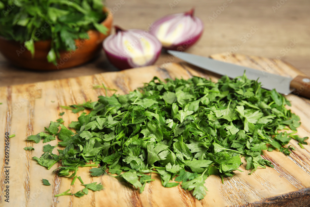 Wooden board with fresh green parsley on table, closeup Wooden board with fresh green parsley on table, closeup
