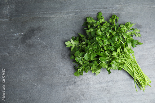 Bunch of fresh green parsley on grey background, view from above. Space for text
