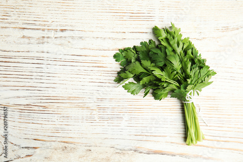 Bunch of fresh green parsley on wooden background, view from above. Space for text