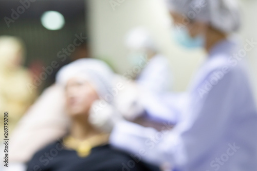 Blurred the surgeon and his assistant performing cosmetic surgery,injection collagen healthy for beauty on face, procedure rejuvenation for treatment skin