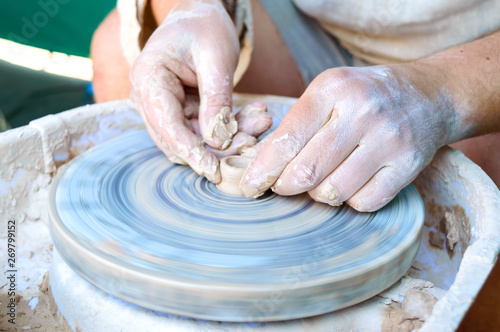 Making pottery on a potter's wheel. Hands craftsman close-up, mold dishes. Master class