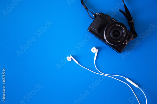 top view with digital camera and headphones White placed on a blue background,Holiday Adventure Travel Lifestyle Concep,Flat lay design creative space for journey