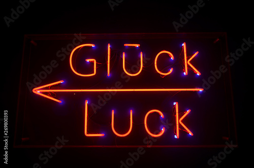 German Word Glück - Word Luck Red Neon Letters on Black Background