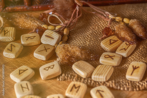 Handmade scandinavian wooden runes on a wooden vintage background. Concept of fortune telling and prediction of the future. © Olga Soloveva