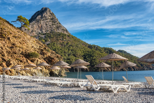 Fototapeta Naklejka Na Ścianę i Meble -  Beach umbrellas and sunbeds on the Adrasan beach in Turkey