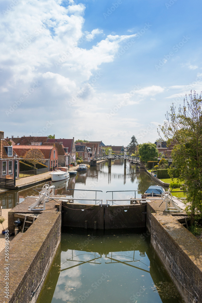 Naklejka premium A canal with lock in a historical city in the lake side district of the Netherlands.