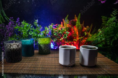 Tea concept. Japanese tea ceremony culture east beverage. Teapot and cups on table with bamboo leaves on sunset