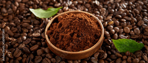 Bowl of freshly ground coffee on roasted beans