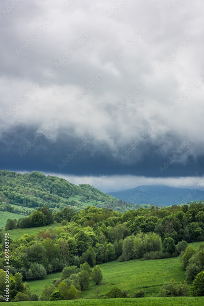 Stormy weather with dramatic rainy clouds over green peaks in Carpathian Mountains, Bieszczady,Poland