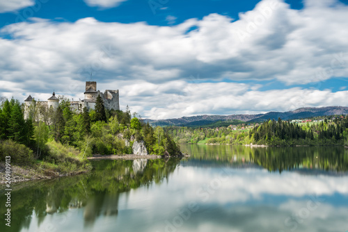 Niedzica castle on hill top, lond exposure motion blur at lake Czorsztyn and clouds on sky