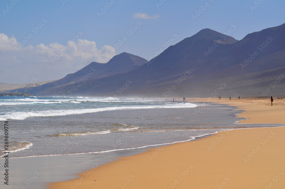 Beautiful sandy ocean beach on a background of mountains. Fuerteventura Canary Islands, Spain