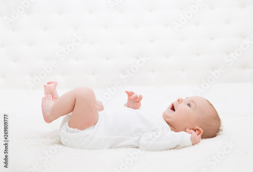 Baby Lying on White Bed, Happy Smiling Infant Kid, Funny Boy Portrait, Six Months Old