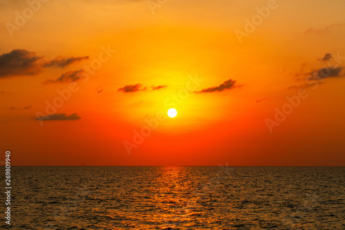 Bright sunset with large yellow sun under the sea surface for backgrounds.