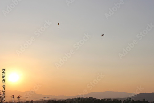 The sun is below the horizon. Travelers are driving Paramotor.