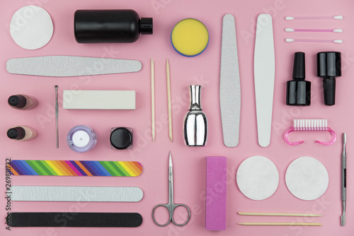Flat lay set of manicure and pedicure tools on trendy pink background. Professional instruments for nail care. Beauty care concept theme.
