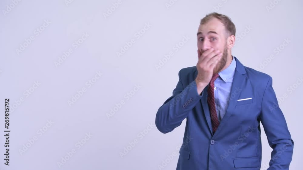 Happy bearded businessman pointing to the side and looking surprised Happy bearded businessman pointing to the side and looking surprised