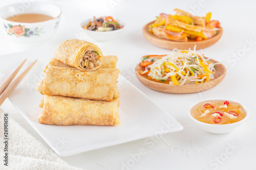 Traditional Chinese tortillas filled - bings in a plate on a white background, salads, Dam Sam snacks and cup of tea.