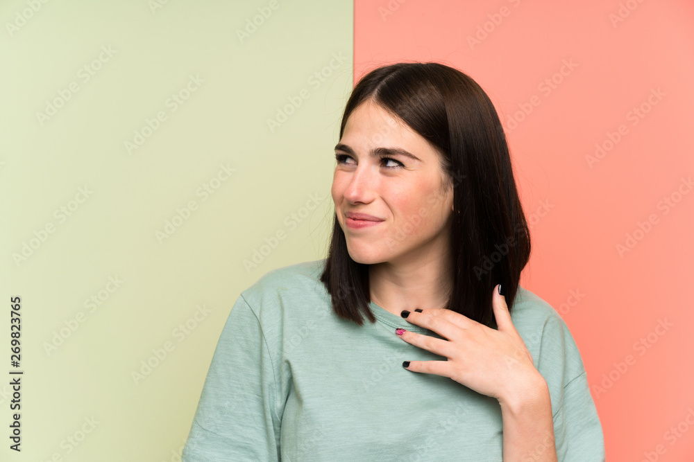 Young woman over isolated colorful wall standing and looking to the side Young woman over isolated colorful wall standing and looking to the side