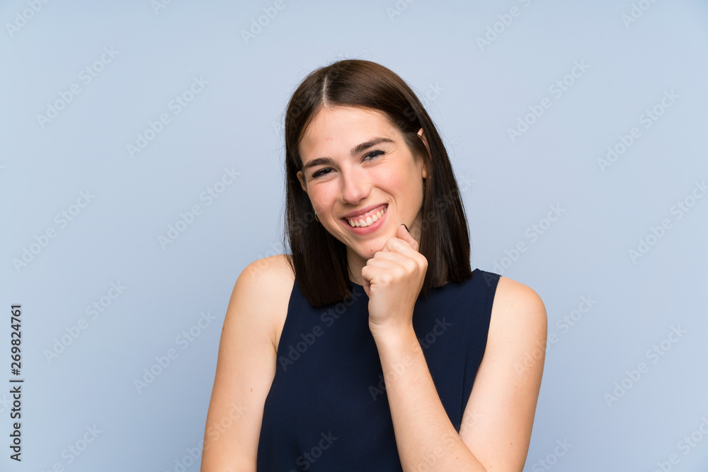 Young woman over isolated blue wall laughing Young woman over isolated blue wall laughing