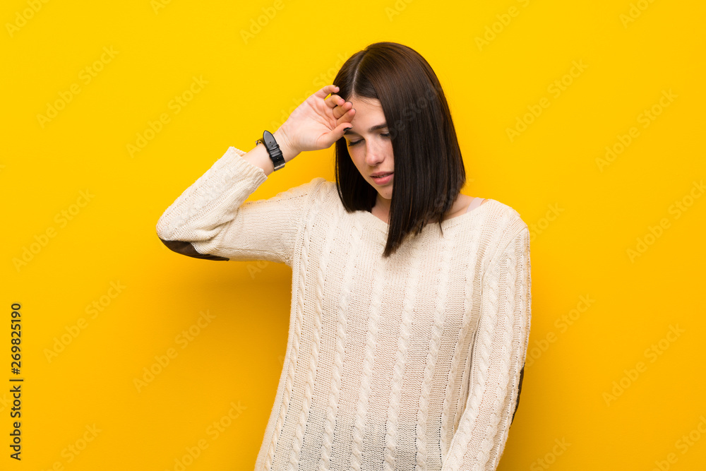 Young woman over isolated yellow wall with tired and sick expression Young woman over isolated yellow wall with tired and sick expression