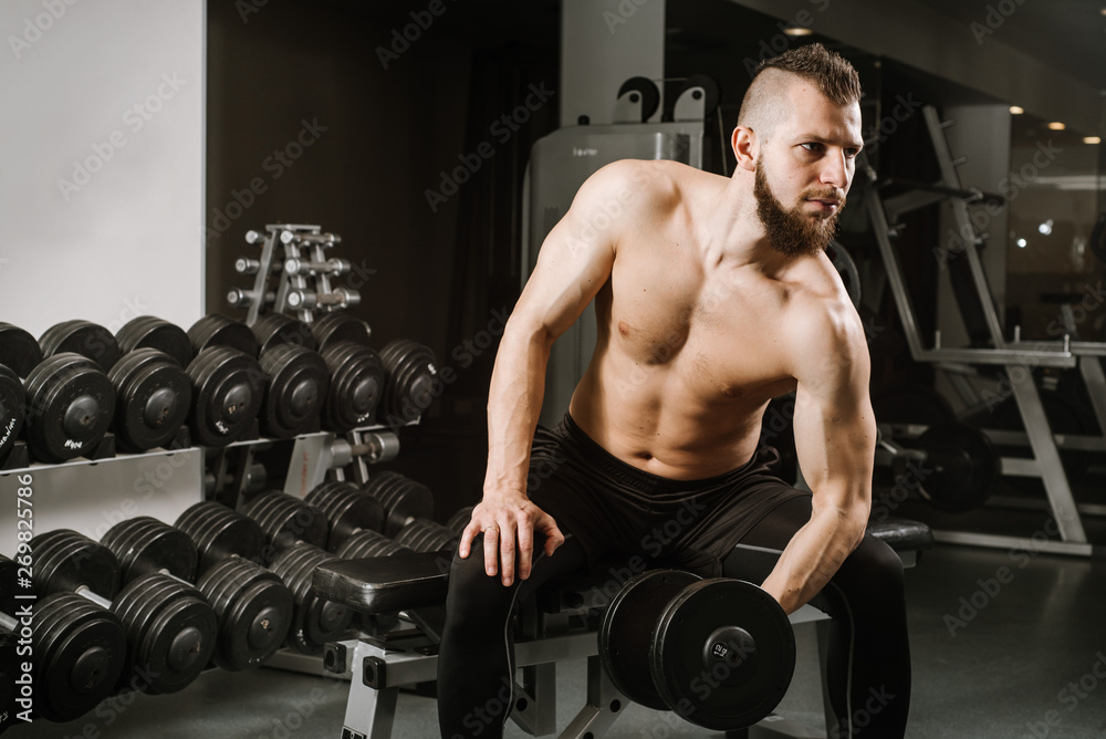 Strog man with dumbbells in the gym Strog man with dumbbells in the gym