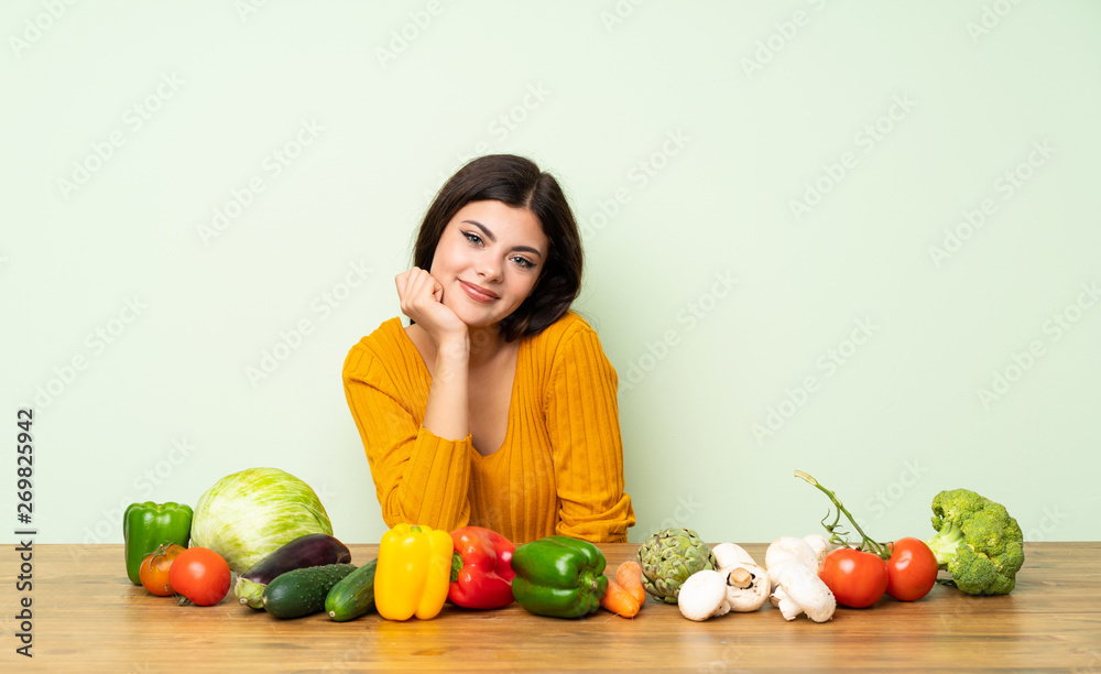 Fototapeta premium Teenager girl with many vegetables laughing